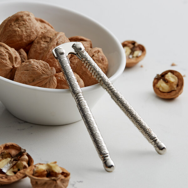 A bowl of walnuts with a pair of Choice zinc plated nutcrackers.