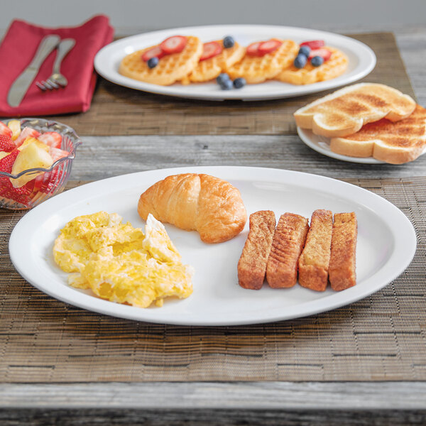 A white Thunder Group Nustone melamine oval platter with breakfast food on a table.