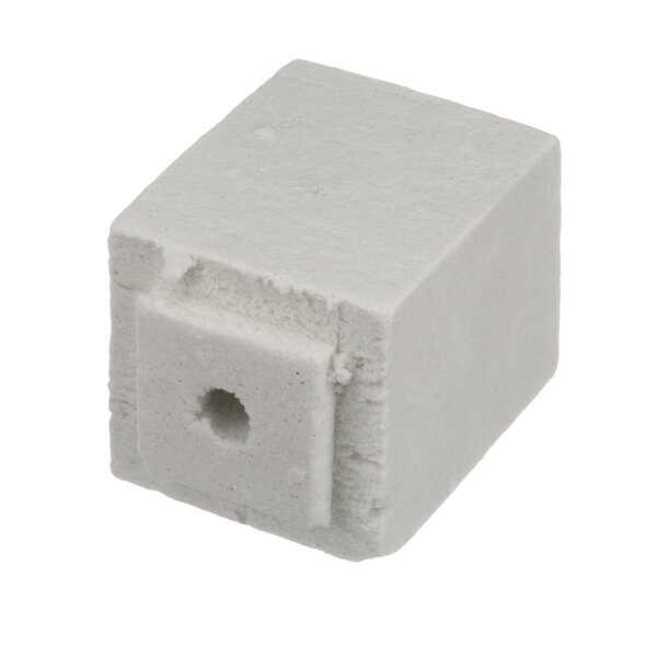 A white cube of Cleveland probe insulation with a hole in it.