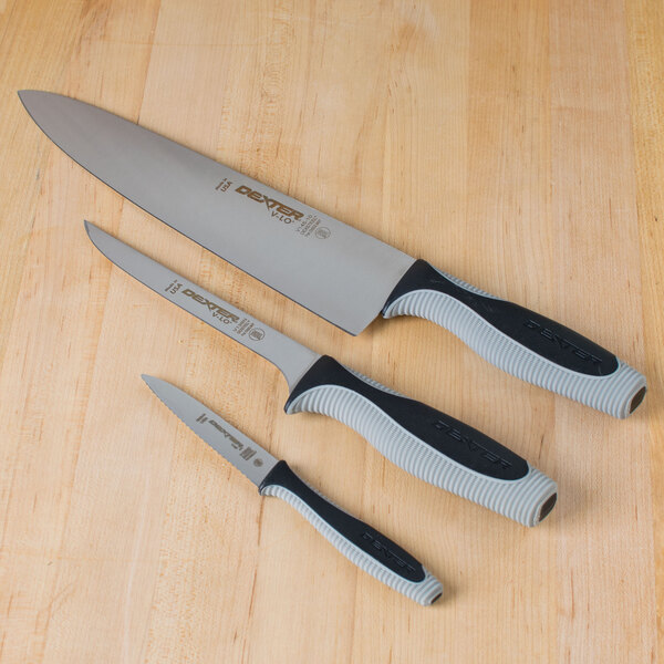 A Dexter-Russell V-Lo 3-piece knife set on a wooden table.