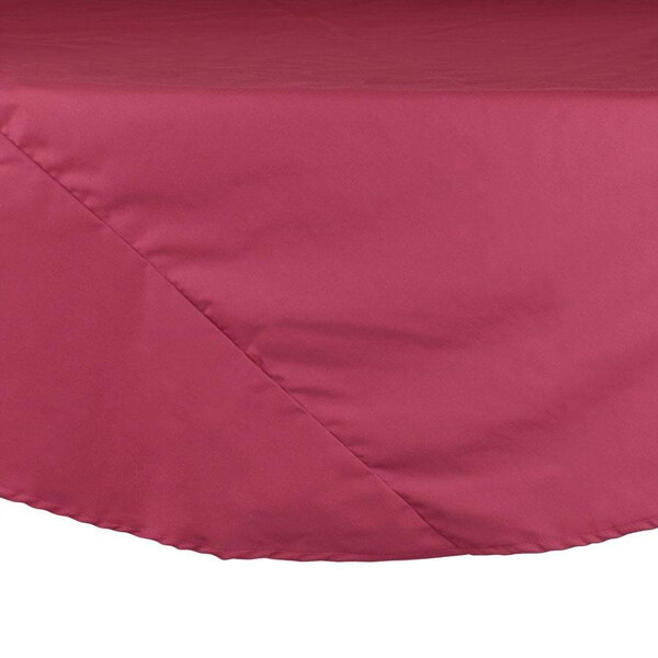 A close up of a mauve Intedge round table cloth with a white hem.