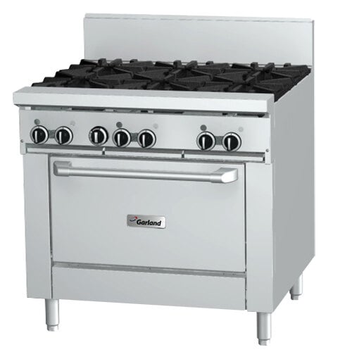A large stainless steel Garland gas range with four burners and black knobs.