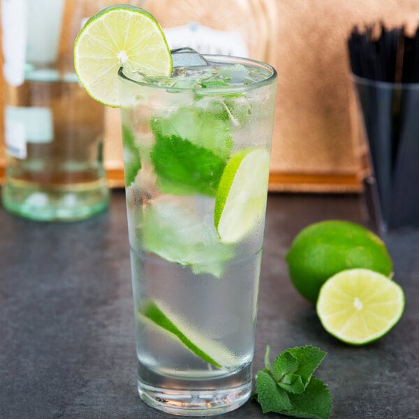 A Libbey stackable cooler glass with water, ice, and a lime wedge.