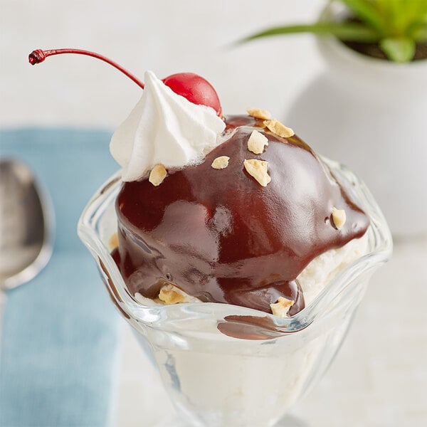 A dessert with hot fudge, whipped cream, and a cherry on top.
