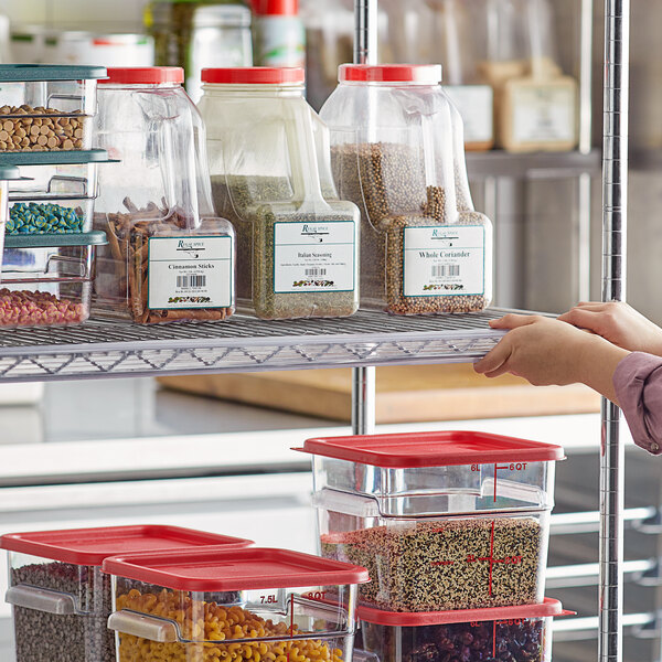 A woman placing a clear plastic label holder on a shelf holding containers of herbs.