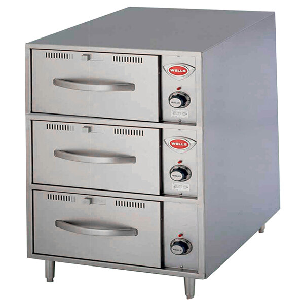A stainless steel Wells freestanding warmer with three drawers and knobs.