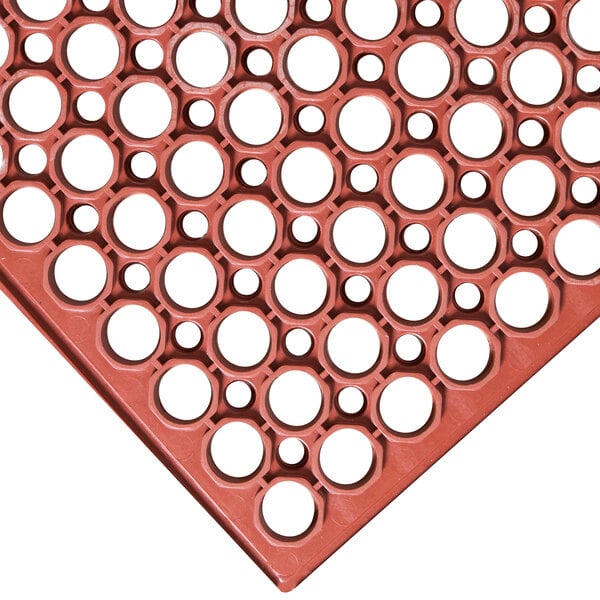A red Cactus Mat VIP TuffDek anti-fatigue floor mat with a plastic grid and holes.