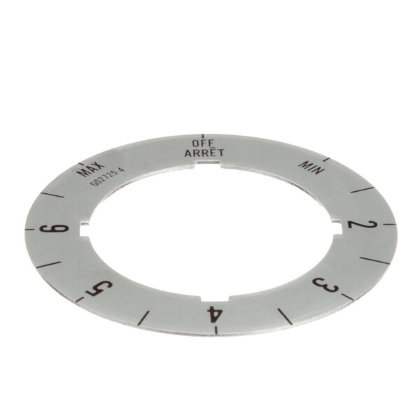 A circular white metal dial with black numbers for a Garland griddle.