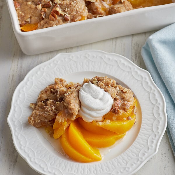 Sliced peaches in light syrup in a white dish.