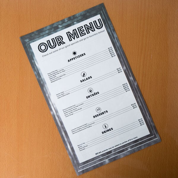 A black menu with a marble border on a table.