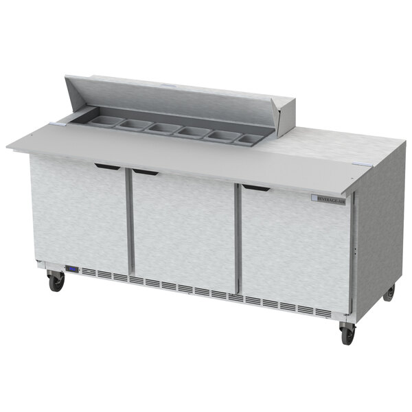 A stainless steel Beverage-Air commercial refrigerator with a cutting board over three doors.