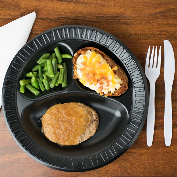 A Dart foam plate with meat, mashed potatoes, and green beans on it.