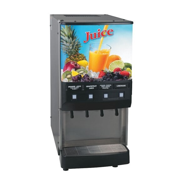 A Bunn replacement lid on a juice dispenser with fruit and a glass of juice.