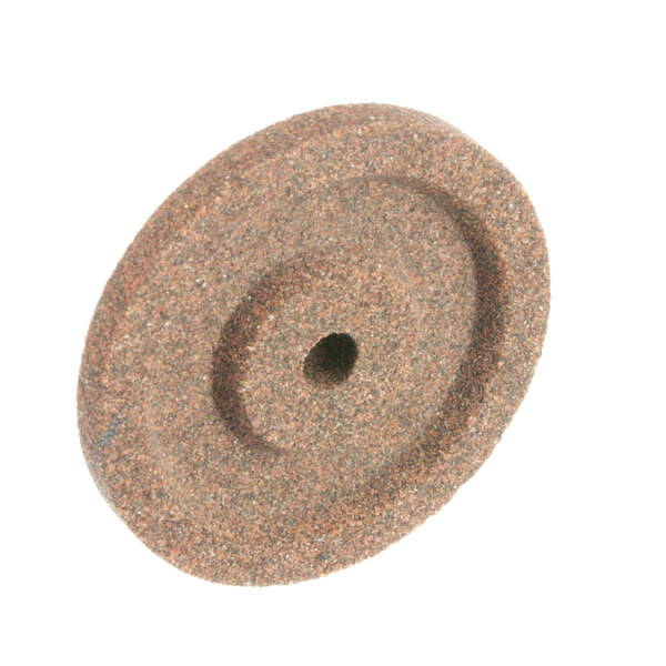 A close-up of a Univex stone grinding wheel with a hole in it.
