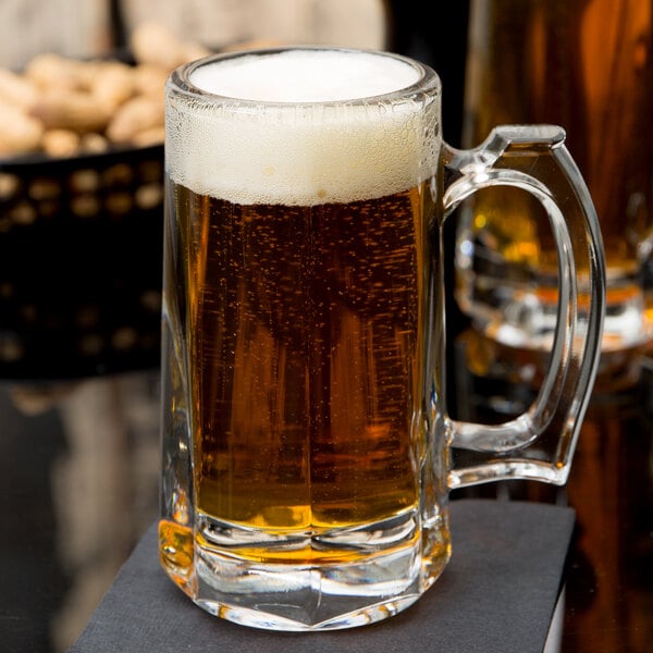 A Libbey beer mug filled with beer on a table.
