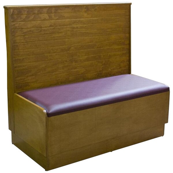 An American Tables & Seating wood wall bench with bead board back and purple cushion.