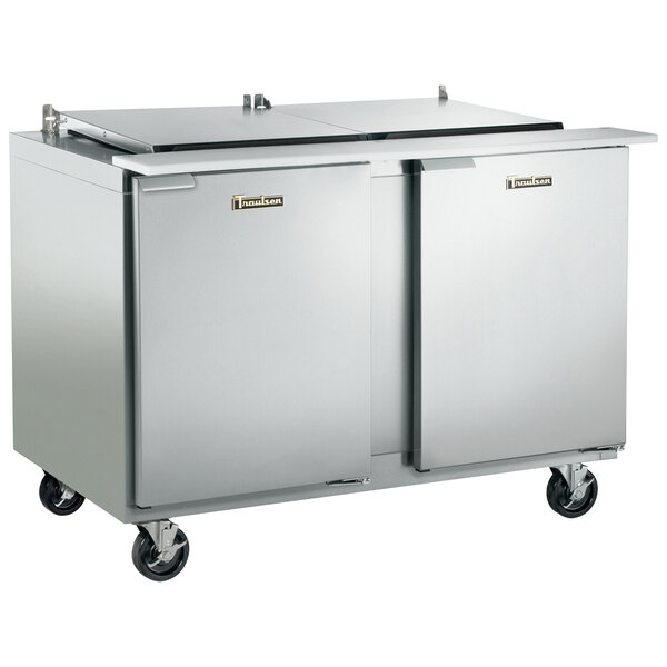 A Traulsen stainless steel refrigerated sandwich prep table with two right hinged doors on wheels.