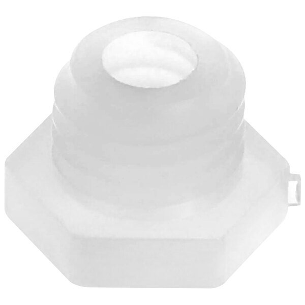A close-up of a white plastic nut with a hole in the middle.