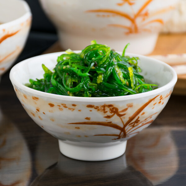 A white melamine bowl filled with green seaweed.