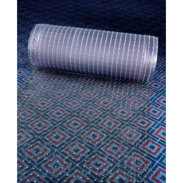 A roll of clear vinyl cactus mat on a carpet.