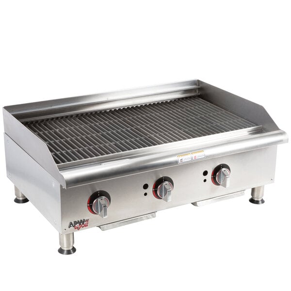 An APW Wyott stainless steel charbroiler on a counter with three burners and knobs.