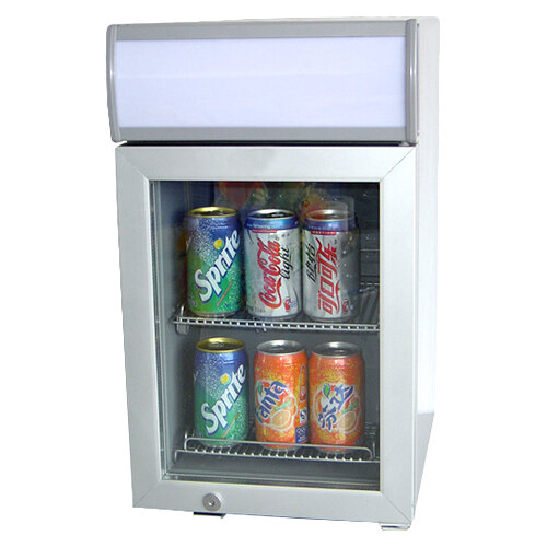 A silver Excellence countertop display refrigerator filled with cans of soda.