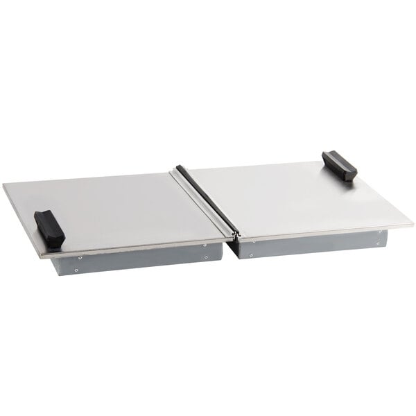 A stainless steel lid on two rectangular metal trays.