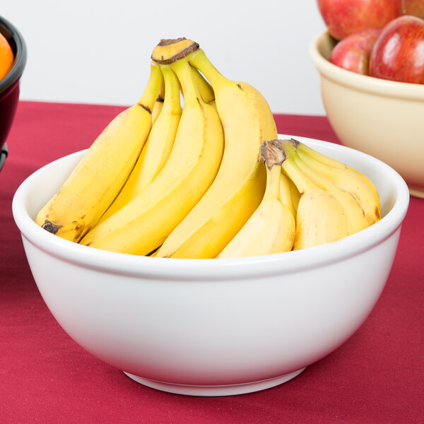 A white Cal-Mil melamine bowl filled with bananas.
