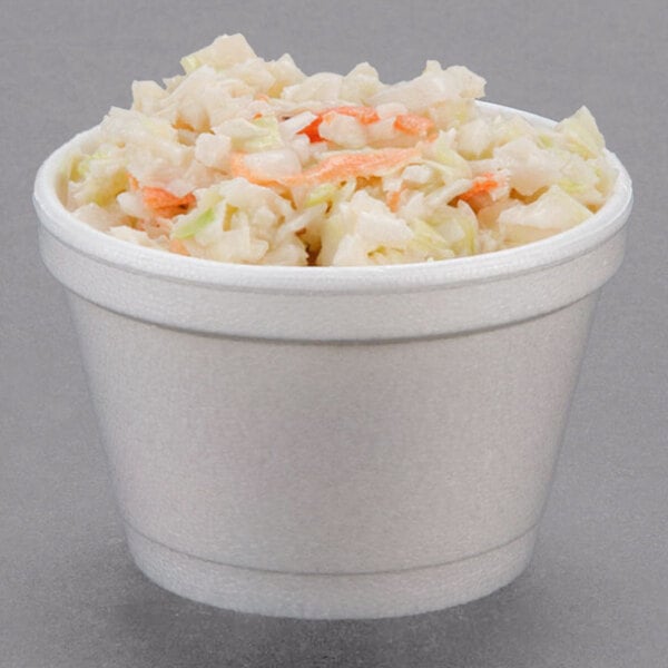 A Dart white foam food container filled with coleslaw.