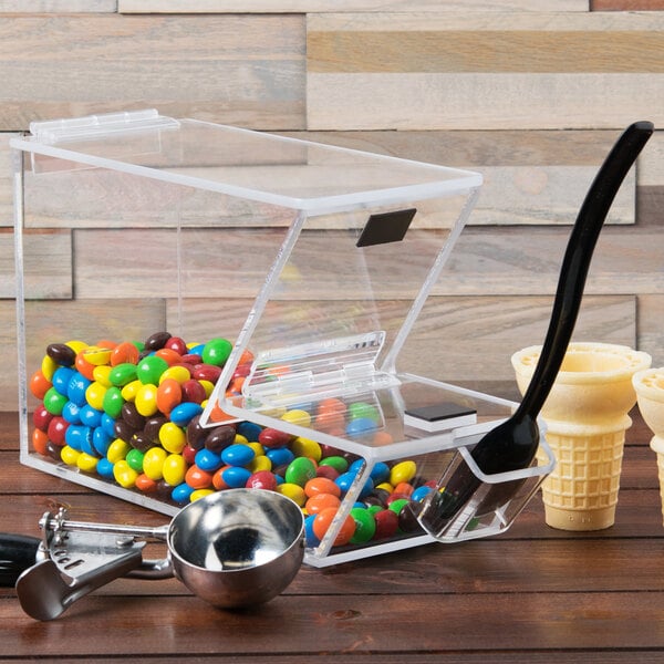 A Cal-Mil stackable topping dispenser with a spoon in a clear container.