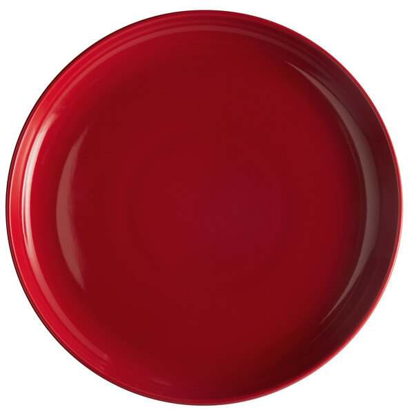 A red Tuxton pizza serving plate with a white circle.
