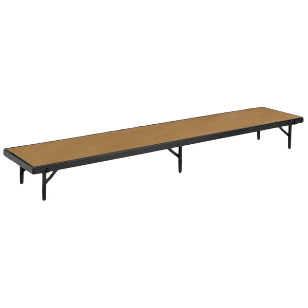 A National Public Seating hardboard stage riser on a long rectangular table with a black frame.