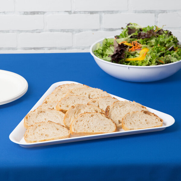 A white Fineline triangular tray with sliced bread and salad on it.