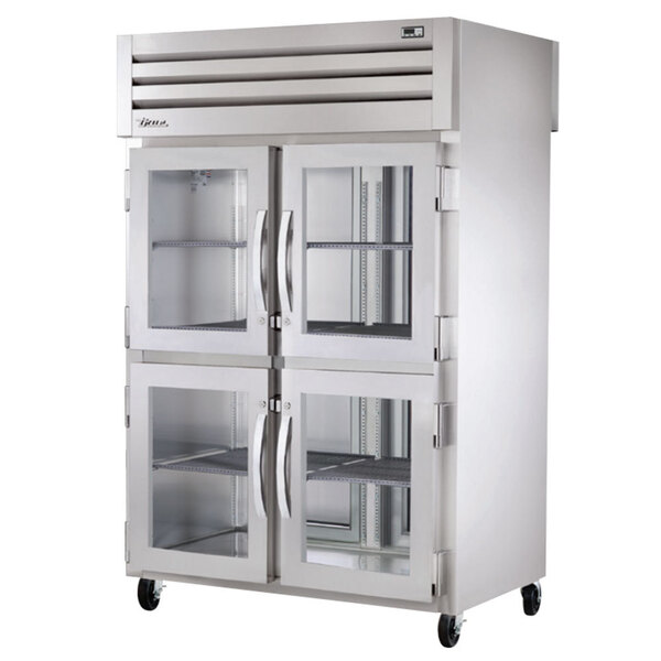 A True stainless steel pass-through refrigerator with half glass doors.