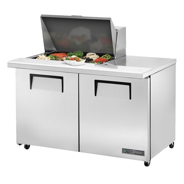 A True stainless steel refrigerated sandwich prep table with food on top.