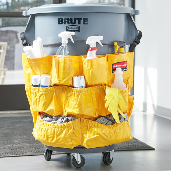 A Rubbermaid BRUTE trash can with cleaning supplies and gloves in it.