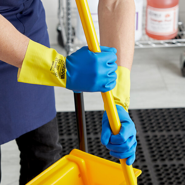 A person wearing blue Cordova dishwashing gloves with a yellow lined mop.