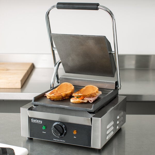 A Galaxy Panini Grill with a sandwich on it cooking.
