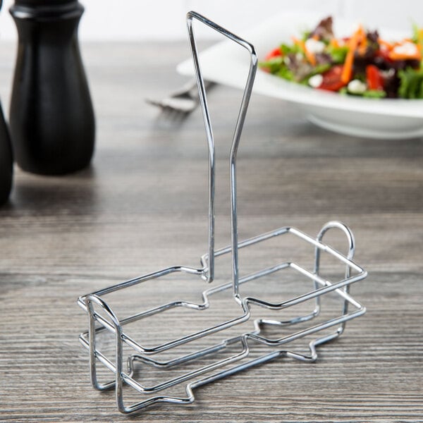 A metal rack holding an olive oil cruet on a table.