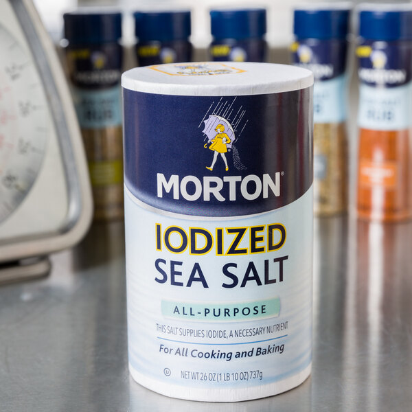 A close-up of a black and white Morton container of iodized sea salt.