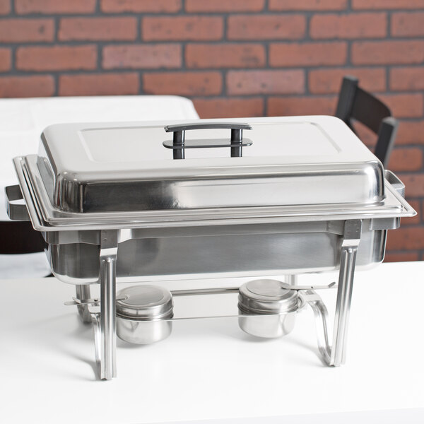 A Vollrath stainless steel chafer with two silver trays on a white table.