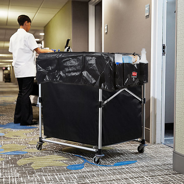 A Rubbermaid laundry cart with a black tarp on it.