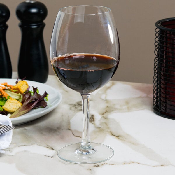 A Reserve by Libbey balloon wine glass filled with red wine on a table.