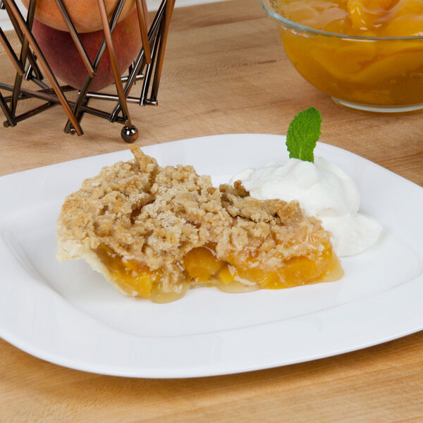 A plate with a slice of peach pie topped with whipped cream.
