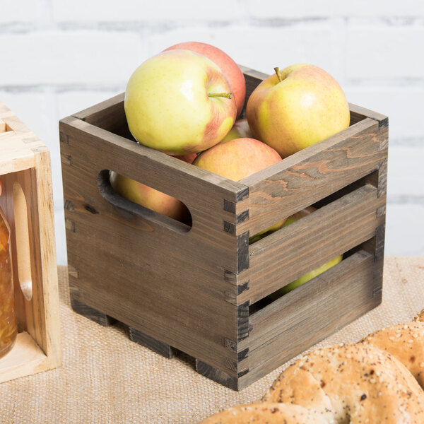 An American Metalcraft vintage wood crate filled with apples on a table.