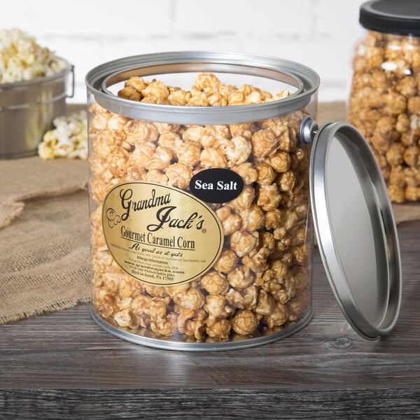A container of Grandma Jack's Gourmet Salted Caramel Popcorn on a table.