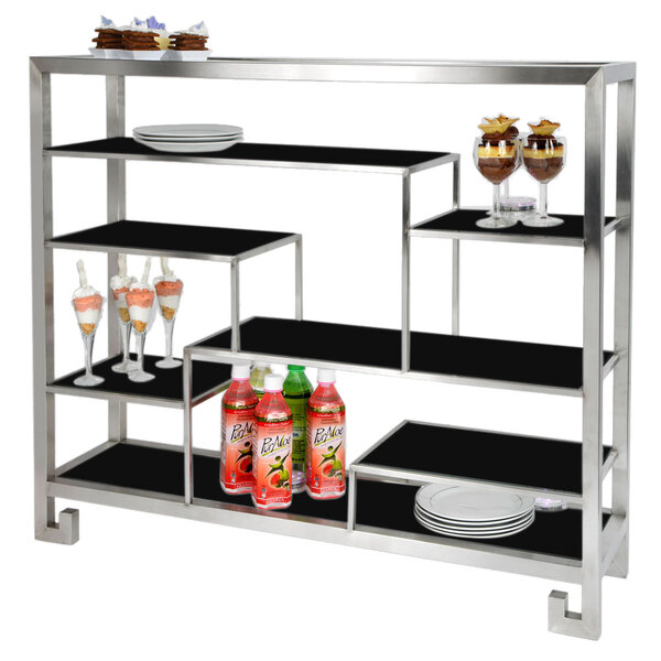 A metal multi-level tabletop display stand with drinks and cups on it.