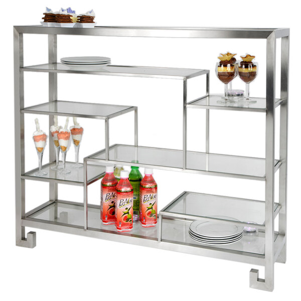 A stainless steel multi-level display stand with drinks and desserts on the glass shelves.