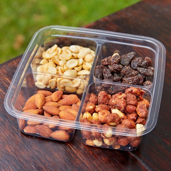 A Fabri-Kal Greenware plastic container with almonds and nuts.