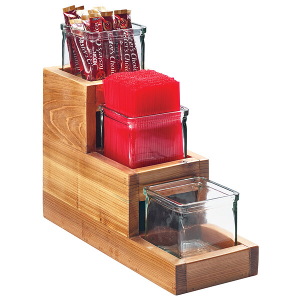A Cal-Mil Madera wooden display with three glass jars on a counter.